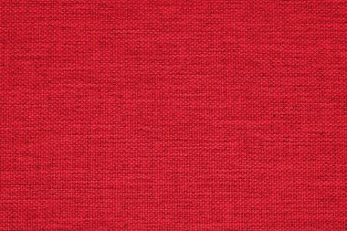 Kırmızı örülmüş bir yüzeye yakın çekim. Doku ketene benziyor. Noel ya da yeni yıl için kumaş arkaplan. Canlı dokulu örülmüş arkaplan