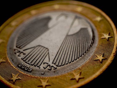 Almanya 'da çıkarılan 1 avroluk madeni para. Federal Kartal 'a karşı. Karanlık, dramatik ekonomik zemin ya da fon. Avrupa Birliği para birimi ve ekonomi haberleri. Makro