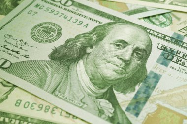 Amerikan kağıt parası. Benjamin Franklin 'in gözlerine odaklı 100 dolarlık banknot. Amerikan banknotları yakın plan. İş ekonomisi ve Amerikan doları. Açık yeşil renkli arka plan. Makro
