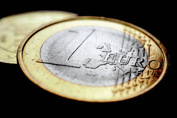 stock image Two euro coins. The focus is on the inscription with the name of the Euro Zone currency on the 1 euro coin. Close-up. Dark illustration about the economy and money of the European Union. Macro