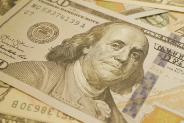Amerikan kağıt parası. Benjamin Franklin 'in gözlerine odaklı 100 dolarlık banknot. Amerikan banknotları yakın plan. İş ekonomisi ve Amerikan doları. Hafif zeytinli arka plan. Makro
