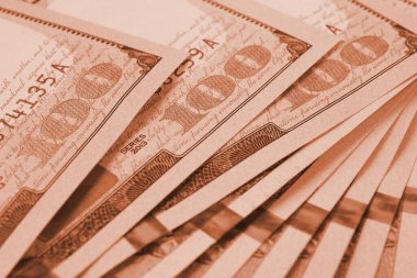 Yüz dolarlık Amerikan banknotları. Yakın plan notların bir parçası. 100 rakamına odaklan. Ekonomik para tasarrufu ve Amerikan doları. Açık kahverengi arkaplan ya da arka plan. Makro