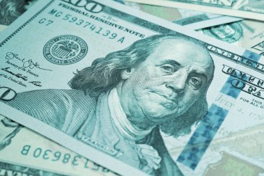 Amerikan kağıt parası. Benjamin Franklin 'in gözlerine odaklı 100 dolarlık banknot. Amerikan banknotları yakın plan. İş ekonomisi ve Amerikan doları. Açık turkuaz renkli arka plan. Makro