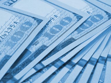 Yüz dolarlık Amerikan banknotları. Yakın plan notların bir parçası. 100 rakamına odaklan. Ekonomik para tasarrufu ve Amerikan doları. Açık mavi renkli arkaplan ya da fon. Makro