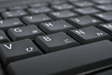Japonca daktilo. Siyah dizüstü bilgisayar klavyesi. Hiragana düğmelerindeki semboller. Japonya 'da elektronik ticaret. Bilişim teknolojileri ve veri depolama. Koyu bilgisayar arkaplanı veya duvar kağıdı