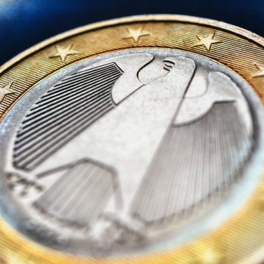Koyu mavi yüzeyde 1 euro var. Para Almanya 'da basıldı. Federal Kartal 'ın görüntüsüne dikkat edin. - Yakın çekim. Avrupa Birliği ekonomisi hakkında parlak kare çizimler. Avro bölgesi haberleri. Makro