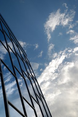 gökyüzü mavi camdan modern bir bina cephe yansıtır