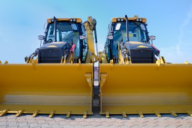 Two new bulldozers on a showcase clipart