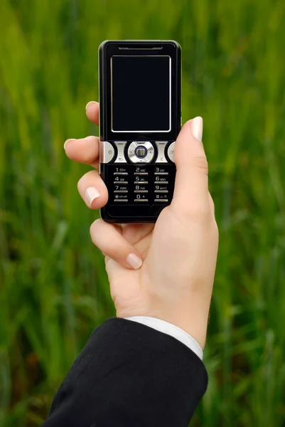 A mão da mulher de negócios mantém um telefone celular — Fotografia de Stock