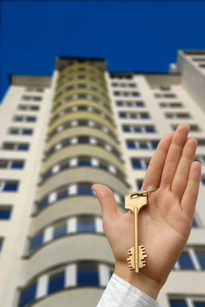 Buying new apartment. The hand holds a key highly. — Stock Photo, Image