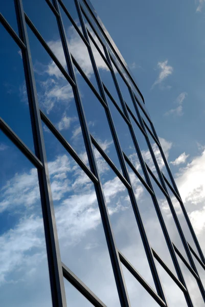 青いガラスから近代的な建物のファサードが天を映す — ストック写真