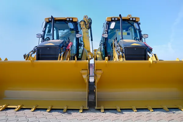 Two new bulldozers on a showcase — Stock Photo, Image