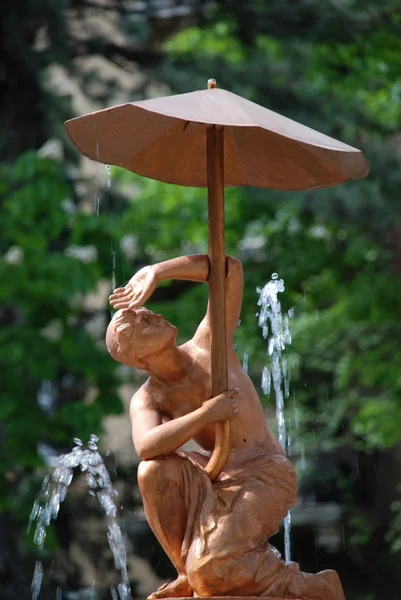 분수는 센터에는 우산으로 사람의 조각 — 스톡 사진