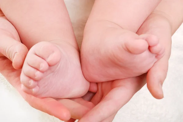 Πόδια μωρό στα χέρια της μαμάς — Φωτογραφία Αρχείου