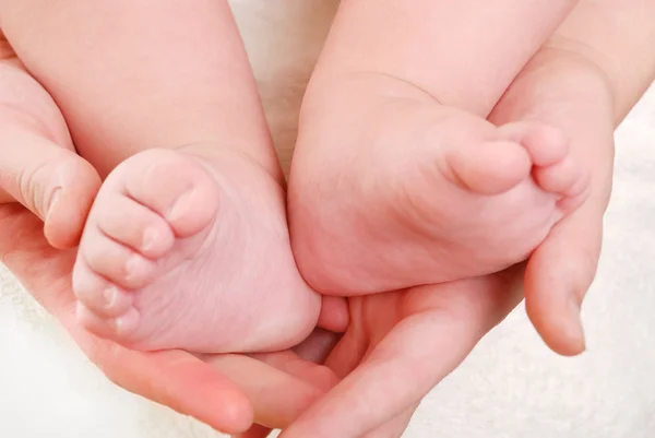 Piedi del bambino nelle mani della mamma — Foto Stock