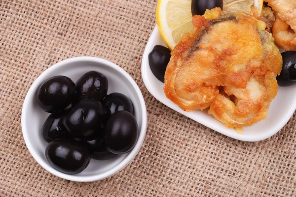 Fried fish with a lemon and olives — Stock Photo, Image