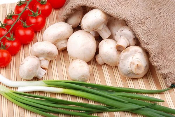 Champiñones, tomates y cebolla en una esterilla —  Fotos de Stock