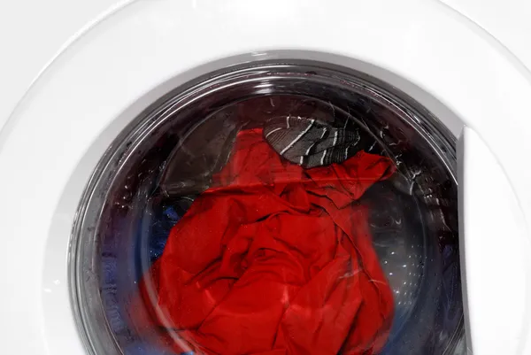 Roupas coloridas em uma máquina de lavar roupa — Fotografia de Stock