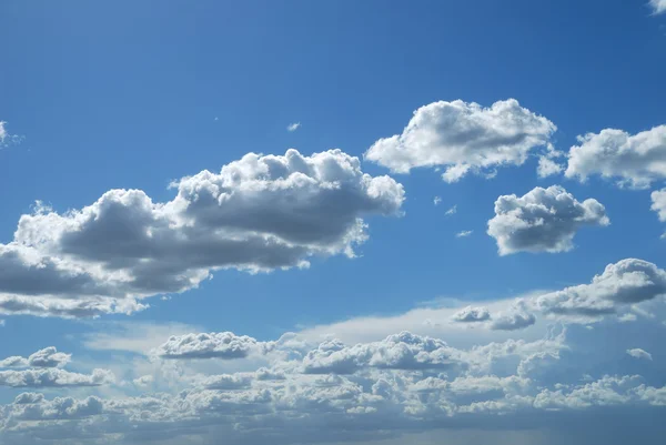 Brillantes nubes soleadas contra el cielo azul — Foto de Stock