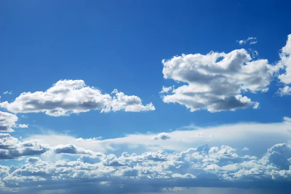 Heldere zonnige wolken tegen blauwe hemel — Stockfoto