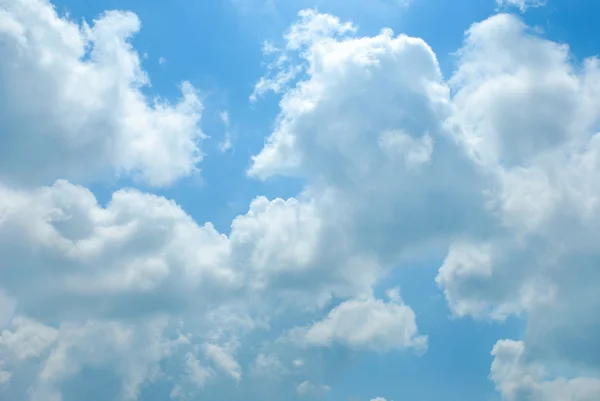 Heldere zonnige wolken tegen blauwe hemel — Stockfoto