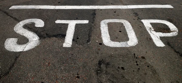 Inscription of "STOP" on asphalt — Stock Photo, Image