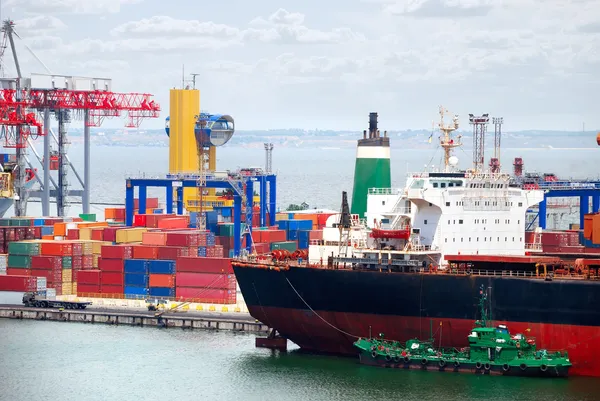 O porto comercial com guindastes, cargas e navio — Fotografia de Stock