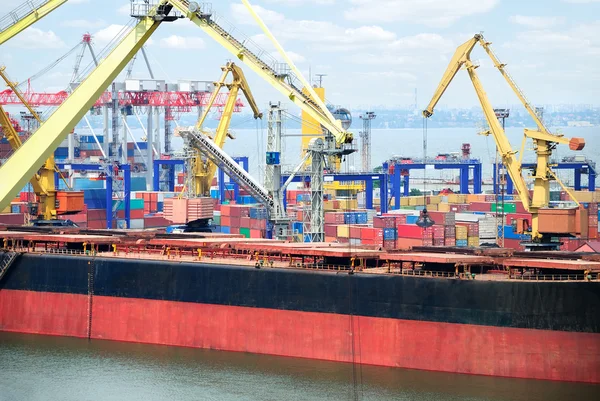 O porto comercial com guindastes, cargas e navio — Fotografia de Stock