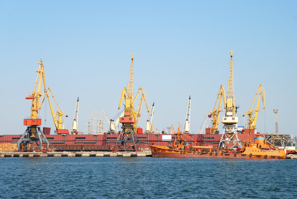 The trading seaport with cranes, cargoes and ship