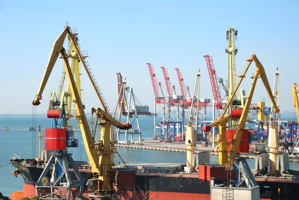 O porto comercial com guindastes, cargas e navio — Fotografia de Stock
