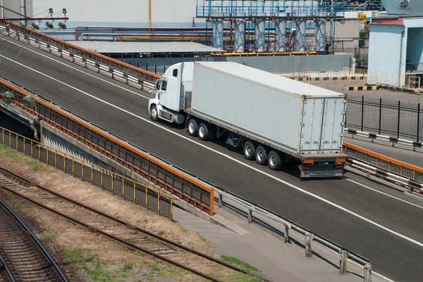 Witte vrachtwagen stations in de buurt van de plant — Stockfoto