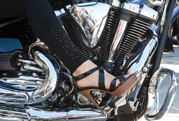 Women foot on a motorcycle engine — Stock Photo, Image