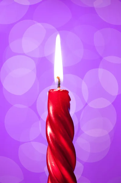 Luz de vela roja sobre fondo violeta — Foto de Stock