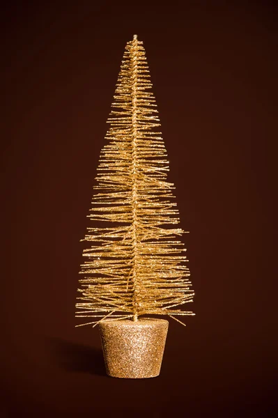 Juguete dorado árbol de navidad en marrón oscuro —  Fotos de Stock