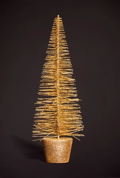 Goldener Spielzeug-Weihnachtsbaum auf dunkelgrau — Stockfoto