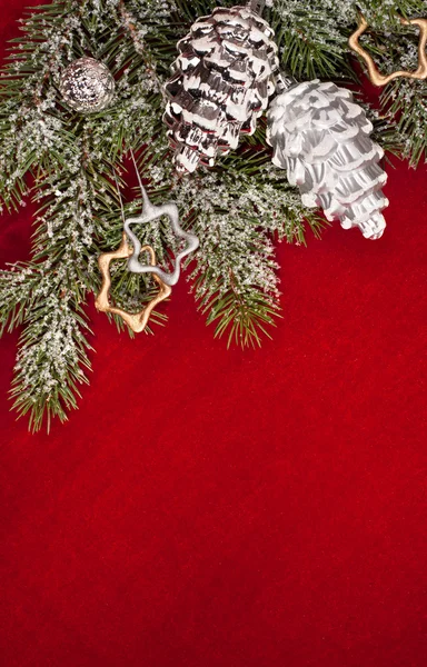 Christbaumschmuck mit Zapfen auf Rot — Stockfoto