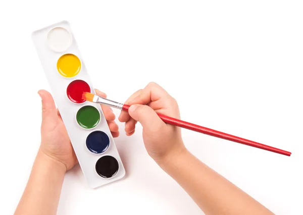 Child's hand paints with watercolors and brush — Stock Photo, Image