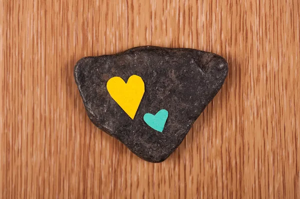 Corazones sobre piedra y fondo de madera —  Fotos de Stock