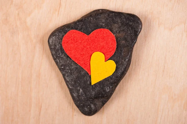 Corazones sobre piedra y fondo de madera —  Fotos de Stock