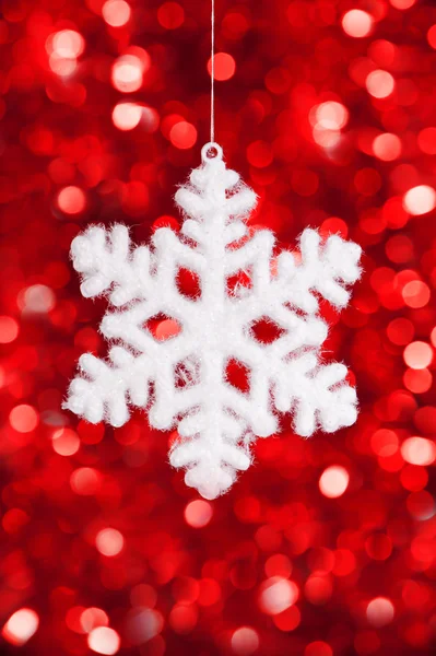 One big snowflake toy on red bokeh background — Stock Photo, Image