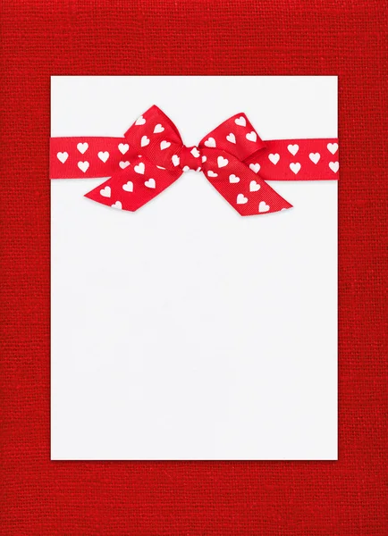 Red bow on paper sheet — Stock Photo, Image