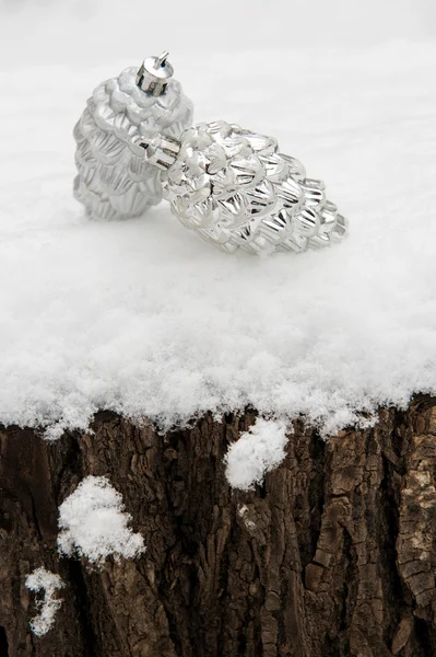 Dos conos de juguete en un tocón de árbol en la nieve — Foto de Stock