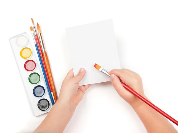 Blank sheet in child hand with watercolor brush — Stock Photo, Image