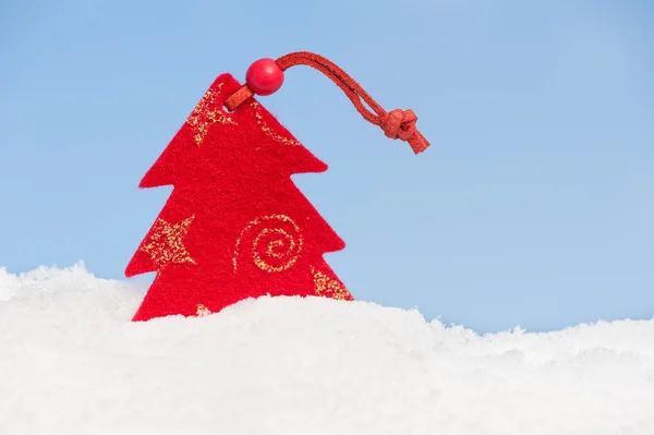 Fir tree toy in snow on sky background — Stock Photo, Image