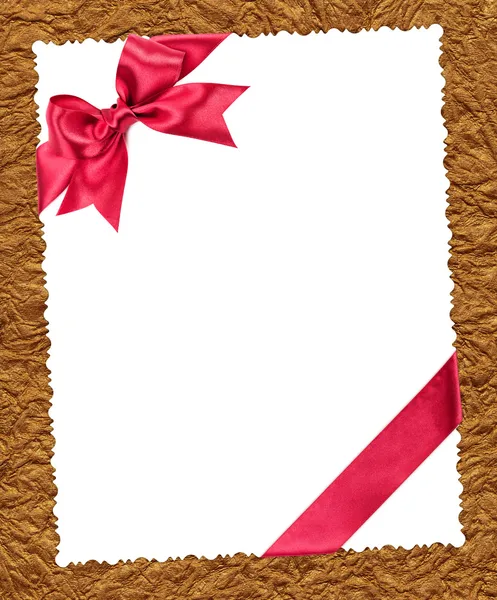 Foglio di carta bianco con fiocco rosso su oro — Foto Stock