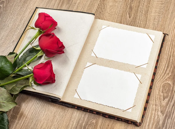 Photo album and roses on wooden Royalty Free Stock Images