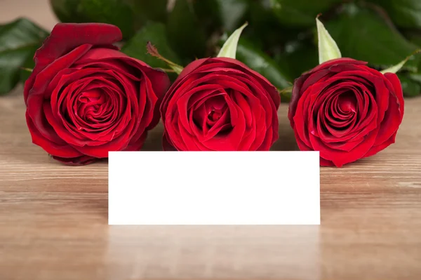 Rote Rosen und weißes Laken auf Holz — Stockfoto