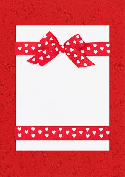 Red bow on paper sheet — Stock Photo, Image