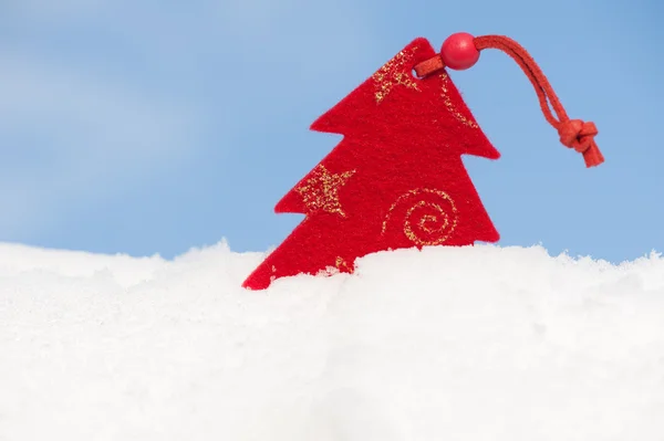 Juguete rojo de Navidad en la nieve contra el cielo —  Fotos de Stock