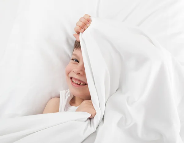 Fröhlicher Junge im Bett — Stockfoto